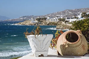 Old flower pots on foreground and Mykonos town and Aegean sea in the background, Cyclades, Greece