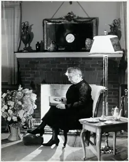 Old Woman In Front Of Fireplace