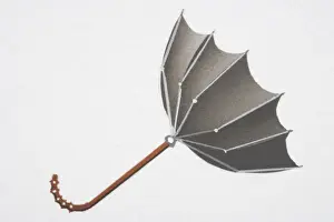 Open umbrella blown upwards from convex into concave shape by strong wind, side view