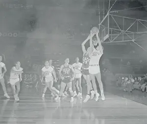 Opposing Basketball Team Players Going for Ball
