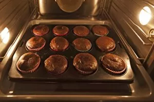 Images Dated 8th September 2014: Oreo brownie cupcakes on a baking tray in the oven