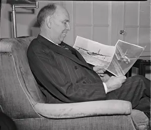 Ralph Owen Brewster Prints: Owen Brewster Looking at Photos of Howard Hughes Plane