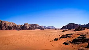 Bedoin Prints: Panoramic view of Wadi Rum with clear blue sky background and some rock boulders