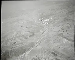 Parachutes Dropping from Military Airplanes over Terrain