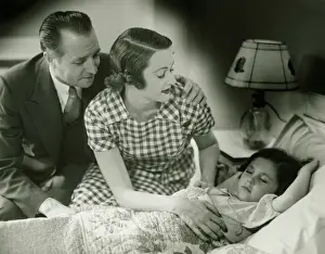 40 49 Years Prints: Parents looking at sleeping daughter (6-7), (B&W)