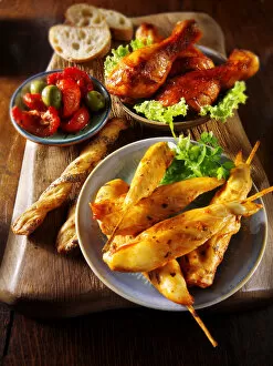 Party buffet with chicken satay and grilled chicken legs
