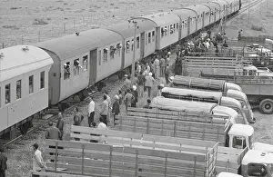 Passengers and Transport Trucks at Train Station