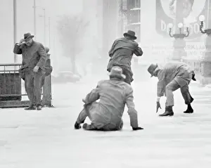 Fedora Prints: Pedestrians Battling Heavy Winds on Icy Sidewalks