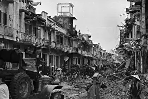 Pedestrians and Soldiers Traveling War Torn Street