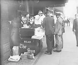 Buying Prints: People buying their newspapers at a newspaper stand in New York City