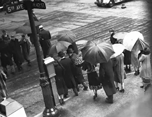 People crossing street in rain, (B&W), elevated view