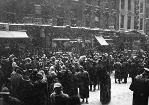 People gather outside the New York Stock Exchange on Wall Street on a Snowy Day