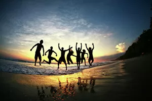 Medium Group Of People Gallery: People jumping on beach at sunset in Costa Rica