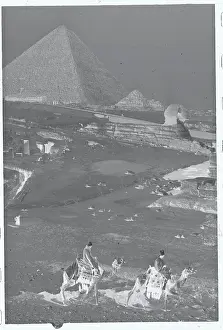 Giza Prints: People Riding Camels with Pyramids and Sphinx in Background
