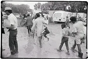 People Walking Through Mud At Camp Site