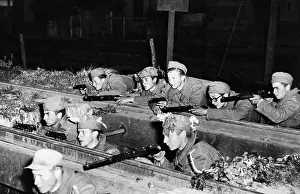 Armed Prints: Peron Troops Shelter on Railroad Tracks