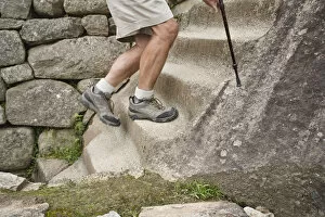 Images Dated 21st April 2008: Peru, Machu Picchu, man climbing stone steps, low section