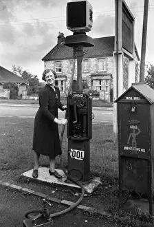 Prints of 1941: Mrs E Weaver, hostess at Tunley's main public house, working a petrol pump. Original Publication: Picture Post - 796 - Tunley Village - unpub Discover the Vision of Haywood Magee – A Master of Mid-Century British Life: Petrol Attendant