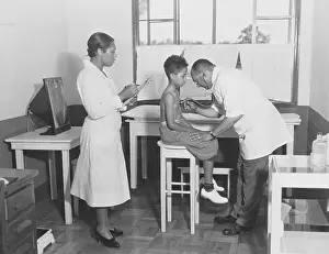 Physician Examining Young Boy at Clinic