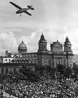 Plane Over Crowd in Front of Cathedral