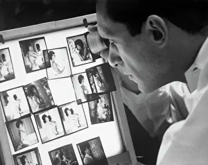 Slide Prints: Playboy Publisher Hugh Hefner Observing Photographs