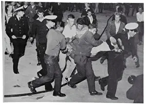 Police Carrying a Resisting Rock and Roll Fan