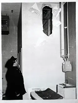 Police Officer Looking at Hole in Wall