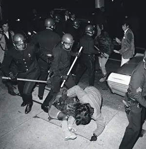 Policeman with Sticks Beating Protesters