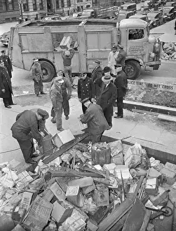 Policemen Dumping Items Into a Sanitation Truck