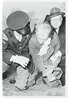 Policemen Holding an Old Man