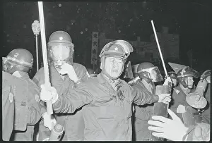 Policemen in Riot Gear Restraining Crowd