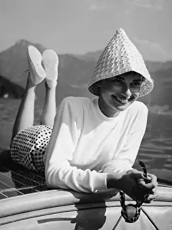 Prints of Portrait of Belgian-born American actress Audrey Hepburn (1929 - 1993) wears a peculiar hat and lies on the back of a motorboat on a lake in Switzerland, early 1950s Elegance Personified – A Classic Art Print Collection: Portrait Of Audrey Hepburn