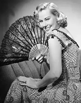 Portrait of blonde woman holding fan