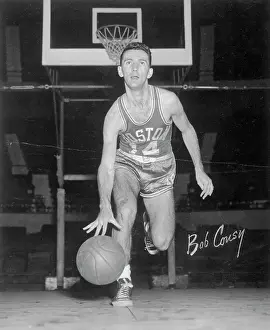 Prints of (Original Caption). Bob Cousy, the American basketball star is shown here in this undated photograph Hoops Through Time: A Visual Journey of Basketball History: Portrait of Bob Cousy Bouncing Basketball