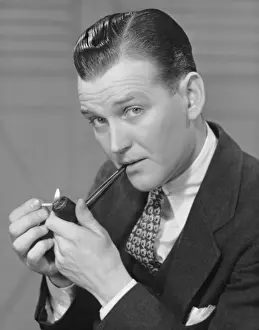 Portrait of businessman lighting pipe