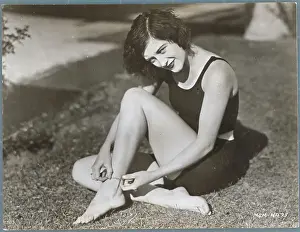 Prints of (Original Caption). Joan Crawford in tennis shorts, seated on a lawn toying with her ankle bracelet A Glamorous Life Captured: Portrait of Joan Crawford