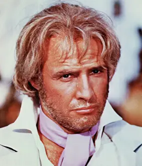 Prints of Publicity photo of Marlon Brando. Head and shoulders, wearing pink ascot, with some beard growth and blonde-streaked hair. Undated The Iconic Moments Captured: Portrait of Marlon Brando