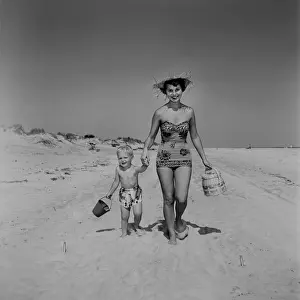 Portrait of mother and son (4-5) walking along beach