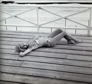 Portrait of young woman in bikini lying on deck