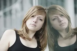 Femininity Prints: Portrait of young woman reflected in a glass pane