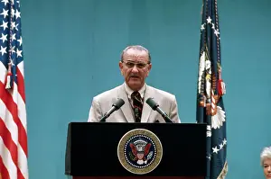 President Lyndon Johnson Speaking at Podium Near Flags