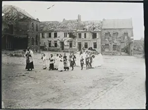 Priest Leading Youngsters in Communion near War Torn Buildings