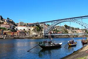 Riverbank Gallery: Rabelo boats and Dom Luis I bridge in Douro river, Porto