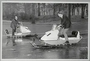 Race Car Drivers Riding Snowmobiles