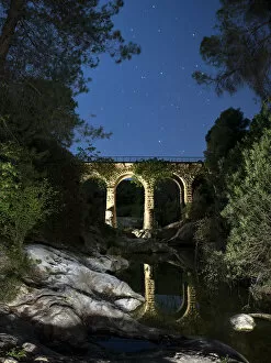 Stone Wall Gallery: Reflection of a bridge on the water of a river in the night
