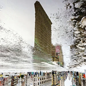 Reflection Of Flatiron Building In Puddle