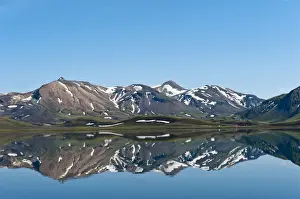 Reflection in the still lake, remnants of snow, panoramic mountain landscape at Alftavatn lake, Laugavegur trekking route, Highlands, Sudurland, Iceland