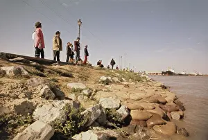 Residents look out at rising murky waters of the mighty Mississippi River