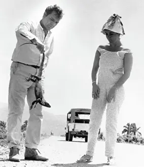 Richard Burton Picks Up An Iguana As Elizabeth Taylor Looks On