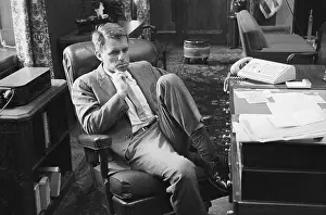 Robert F. Kennedy Sitting With His Leg Propped at His Desk